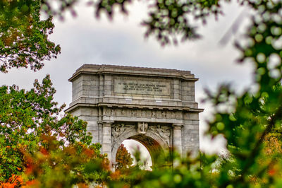 Looking through bright autumn orange leaves at the national memorial arch at valley forge national p