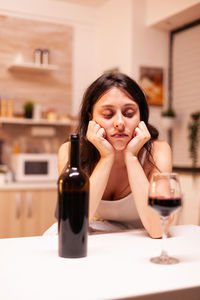 Portrait of young woman sitting on table