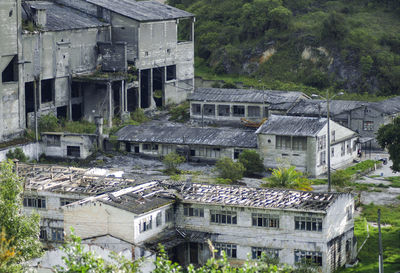 Houses against trees on mountain. abandoned factory