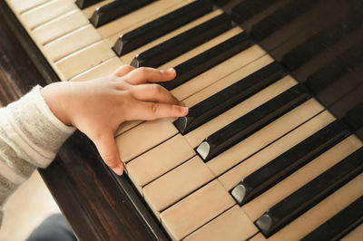 Cropped hand of baby playing piano