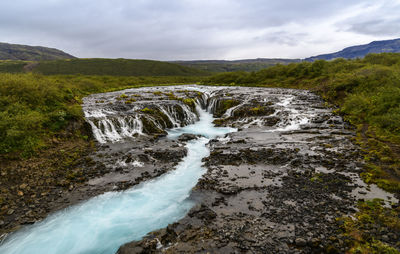 Scenic view of waterfall against sky