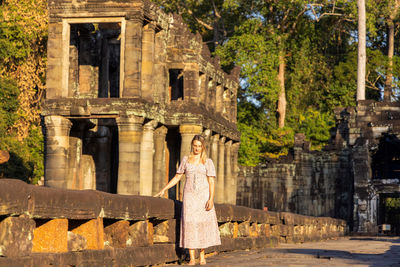 Rear view of woman standing against historic building