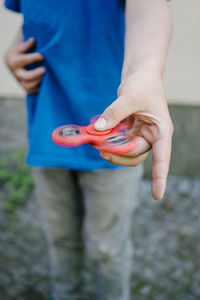 Low section of child holding fidget spinner
