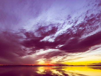 Scenic view of dramatic sky over sea during sunset