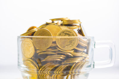 Close-up of glass jar on table against white background