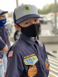 Portrait of boy wearing uniform standing outdoors