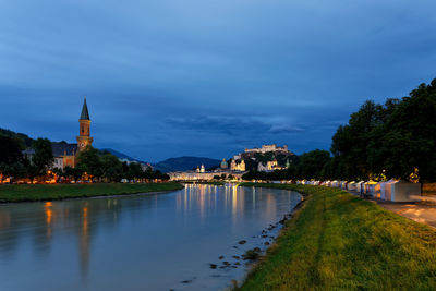 View of buildings at waterfront against cloudy sky