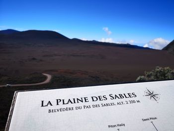 Information sign on landscape against blue sky