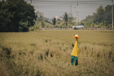 Rear view of woman standing on field