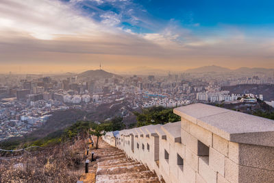 View of cityscape against cloudy sky