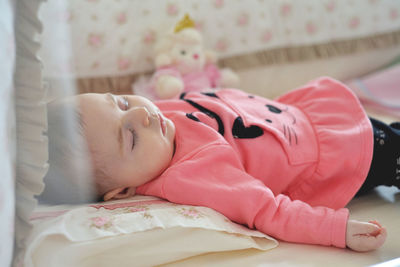 Cute baby girl sleeping on bed at home