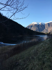 Scenic view of lake by mountains against sky