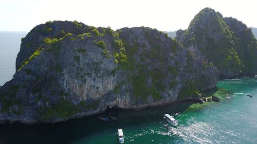 Scenic view of cliff by sea against clear sky