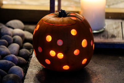 Close-up of illuminated pumpkin on pebbles