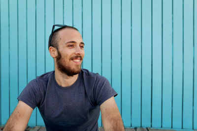 Portrait of smiling man against blue wall