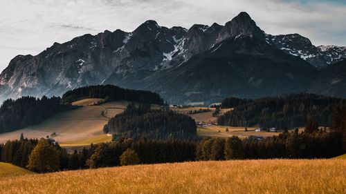 Scenic view of field and mountains against sky