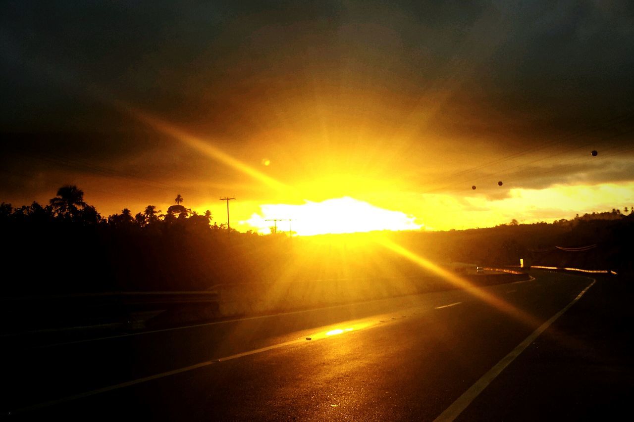 sunset, sun, sunbeam, orange color, sky, sunlight, silhouette, lens flare, cloud - sky, beauty in nature, scenics, nature, tree, tranquility, tranquil scene, transportation, back lit, outdoors, idyllic, bright