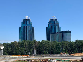 View of modern buildings against clear blue sky