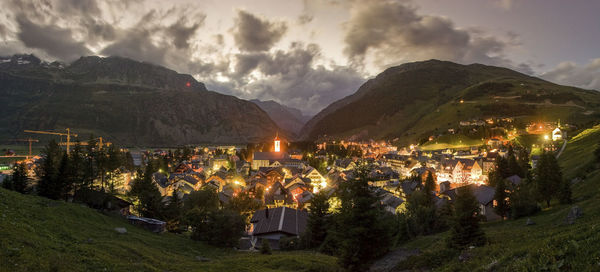 Panoramic view of townscape by mountains against sky