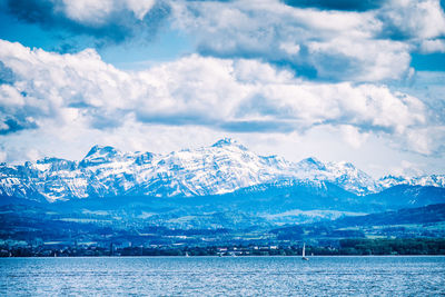 Small sailing ship on lake constance with mighty and snowy alps in the background