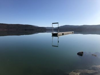 Scenic view of lake against clear blue sky