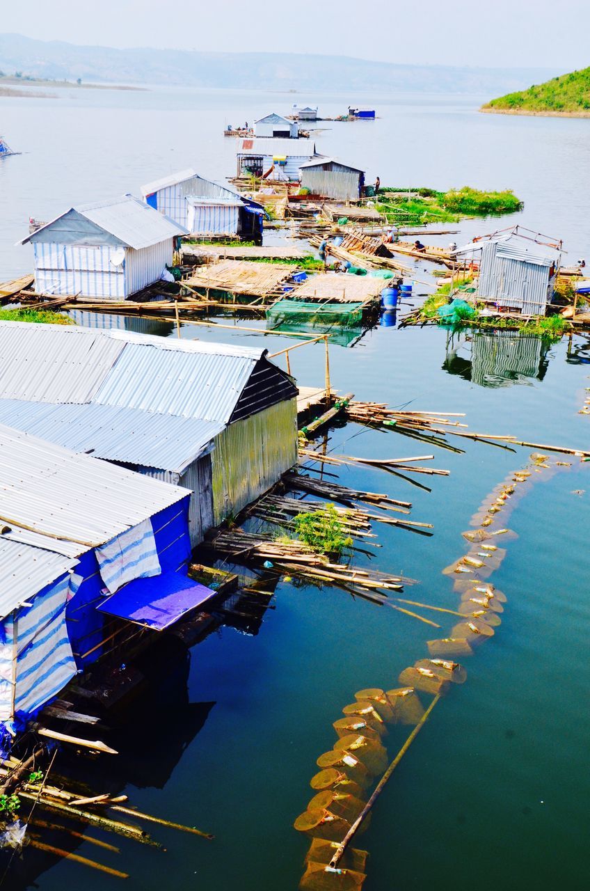 water, moored, built structure, nautical vessel, architecture, harbor, reflection, building exterior, boat, high angle view, lake, day, waterfront, outdoors, sea, no people, transportation, sky, mast, nature