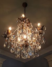 Low angle view of illuminated light bulb hanging on ceiling