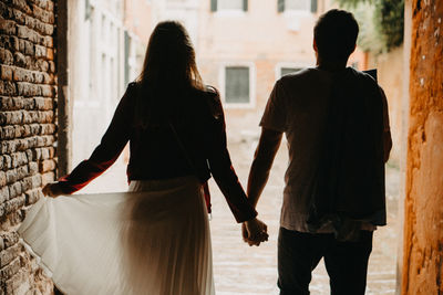 Rear view of couple walking in city