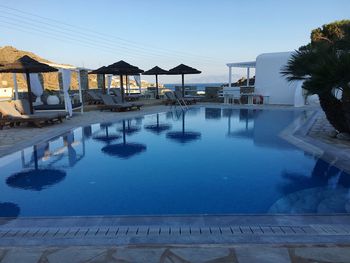 Swimming pool by sea against clear blue sky