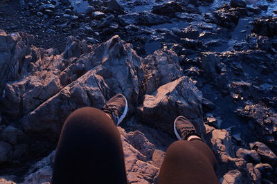 Low section of woman sitting on rock formation