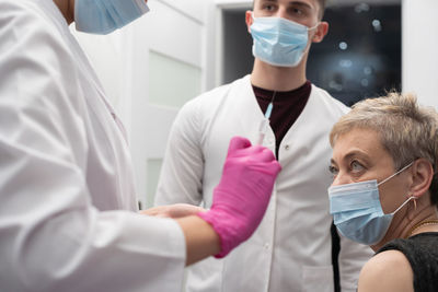 Midsection of doctor examining patient in laboratory