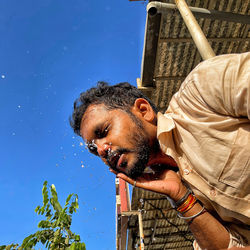 Low angle view of man against blue sky