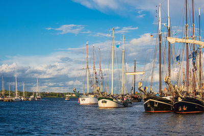 Sailboats moored in sea against sky