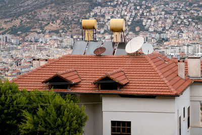 Barrels of water heated by solar batteries installed on roof of house. concept saving electricity.