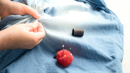 Close-up of hand holding red ball on bed