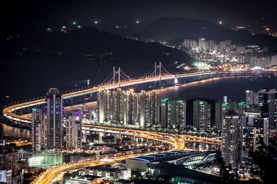 High angle view of illuminated bridge and city at night