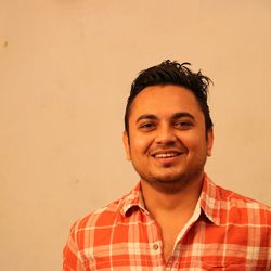 Portrait of smiling young man against wall