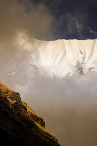 Low angle view of snowcapped mountain against sky