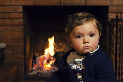 Portrait of cute boy against fire place