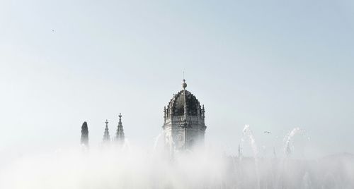 High section of mosteiro dos jeronimos against sky during foggy weather