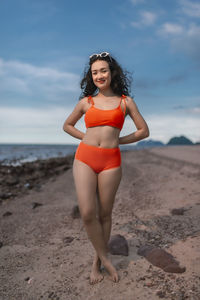 Portrait of young woman standing at beach