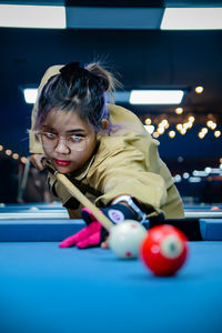 Portrait of girl playing pool