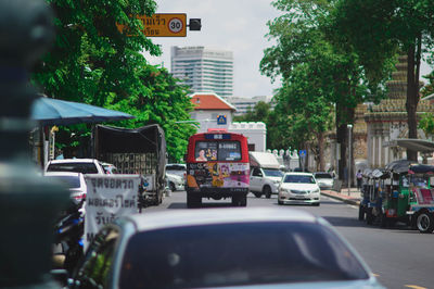 Cars on road by buildings in city