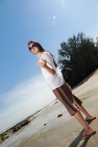 Portrait of woman gesturing at beach