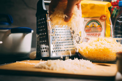 Cheddar cheese grated as close-up shot on an old vintage wooden table