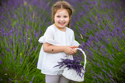 Cute girl holding flowers on field