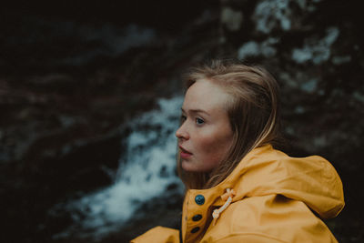 Portrait of young woman looking away outdoors