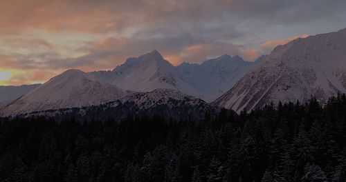 Scenic view of snowcapped mountains against sky during sunset