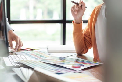 Midsection of woman holding umbrella with text on table