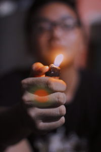 Close-up of hand holding lit candles